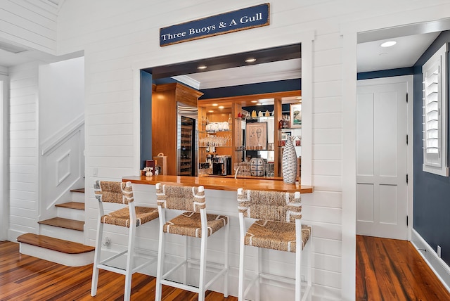 bar with hardwood / wood-style flooring and wooden walls