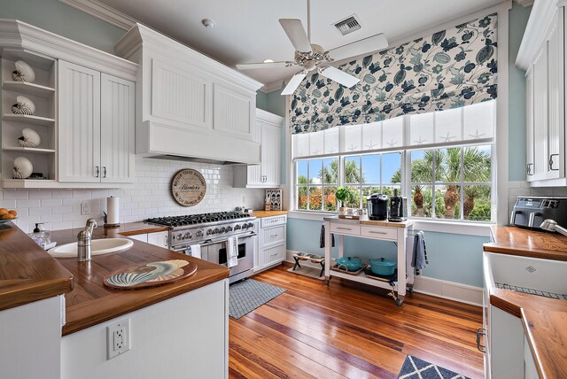 kitchen with range with two ovens, white cabinets, and wooden counters