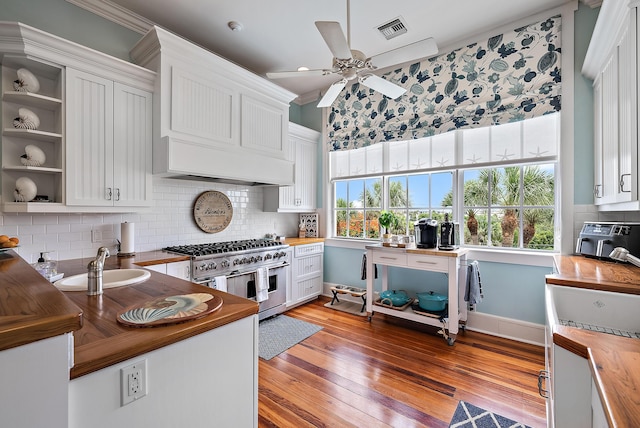 kitchen with butcher block counters, double oven range, and white cabinets