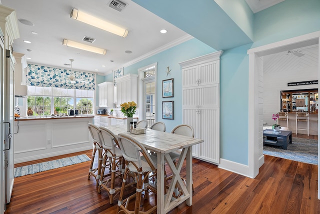 dining room with dark hardwood / wood-style floors and ornamental molding