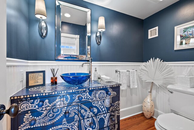 bathroom with wood-type flooring, toilet, and vanity