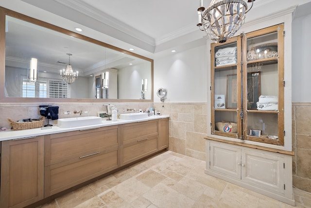 bathroom with vanity, a chandelier, ornamental molding, and tile walls