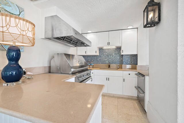 kitchen featuring pendant lighting, white cabinetry, sink, ventilation hood, and kitchen peninsula