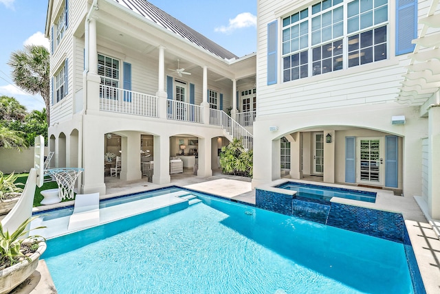 back of house featuring an outdoor living space, a balcony, ceiling fan, a swimming pool with hot tub, and a patio