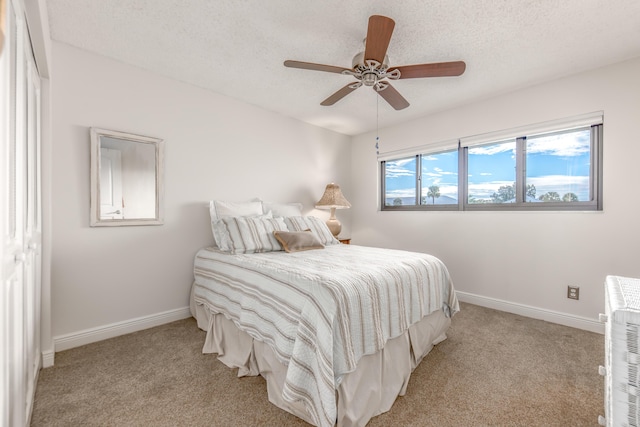 carpeted bedroom featuring ceiling fan, a closet, heating unit, and a textured ceiling