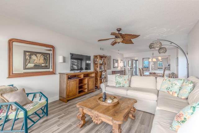 living room featuring ceiling fan and a textured ceiling