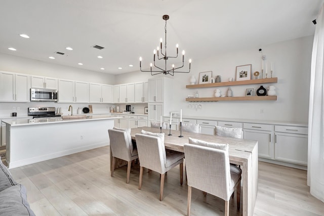 dining space with sink and light hardwood / wood-style flooring