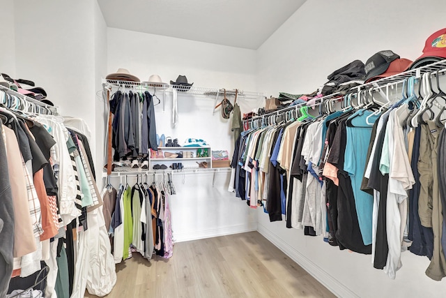 walk in closet with light hardwood / wood-style flooring