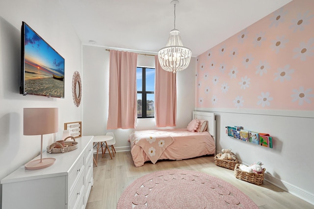 bedroom with light wood-type flooring and a notable chandelier