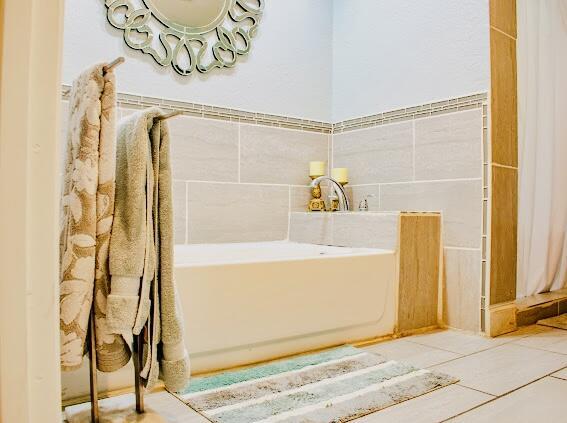 bathroom with a washtub and tile patterned flooring