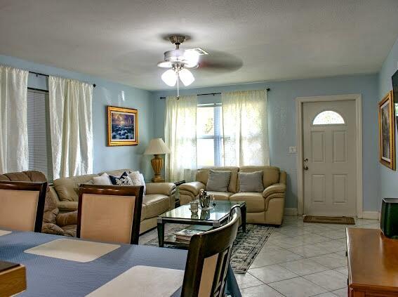 tiled living room with ceiling fan