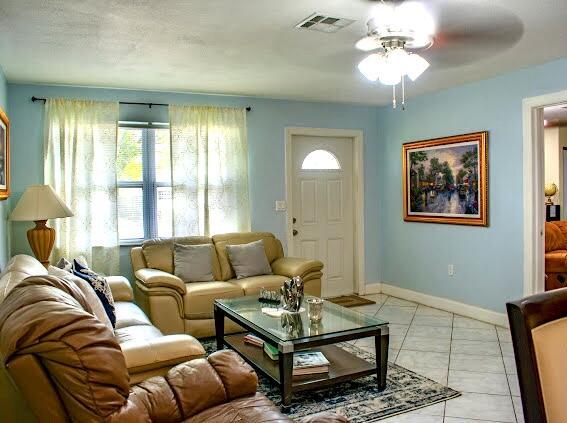 tiled living room with ceiling fan