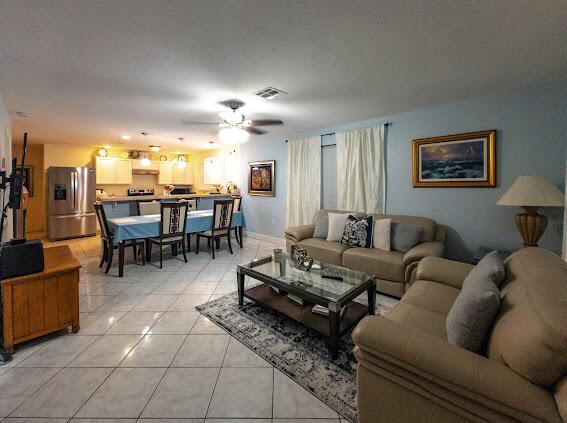 living room with ceiling fan and light tile patterned floors