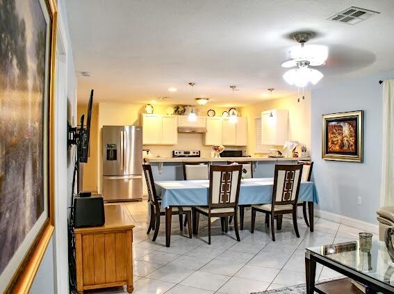 dining space featuring ceiling fan and light tile patterned flooring