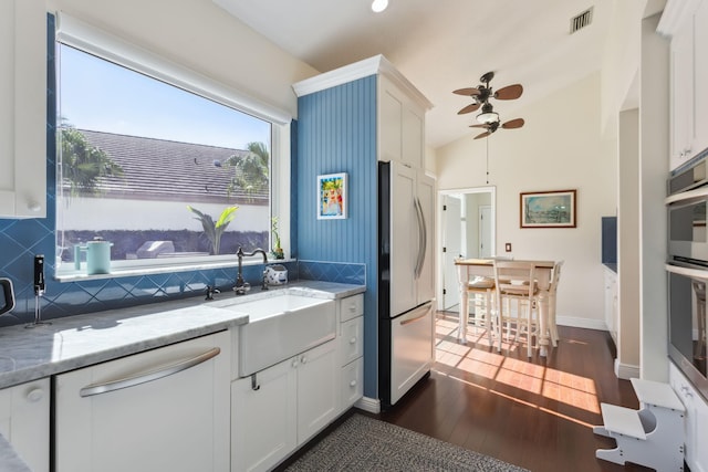 kitchen featuring dark wood-type flooring, refrigerator, light stone counters, tasteful backsplash, and white cabinets