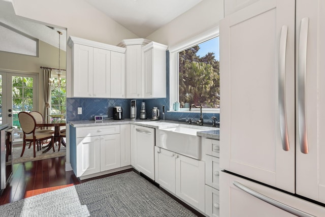 kitchen featuring sink, backsplash, vaulted ceiling, and white cabinets