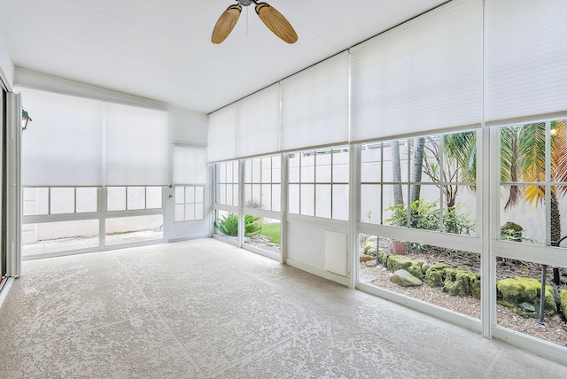 unfurnished sunroom featuring ceiling fan