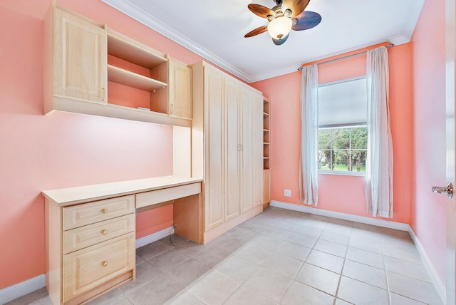 unfurnished office featuring crown molding, ceiling fan, built in desk, and light tile patterned floors