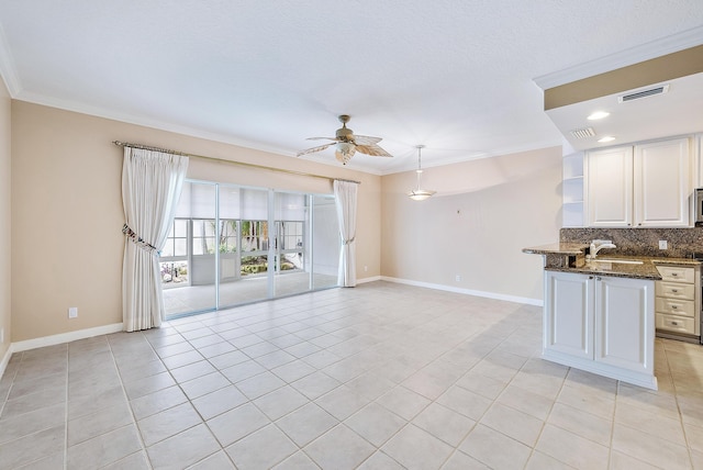 unfurnished living room with light tile patterned flooring, ceiling fan, ornamental molding, and sink