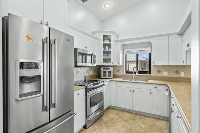 kitchen featuring sink, backsplash, white cabinets, and appliances with stainless steel finishes