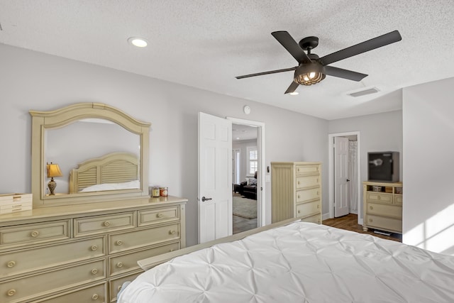 bedroom featuring a textured ceiling, ceiling fan, and wood-type flooring