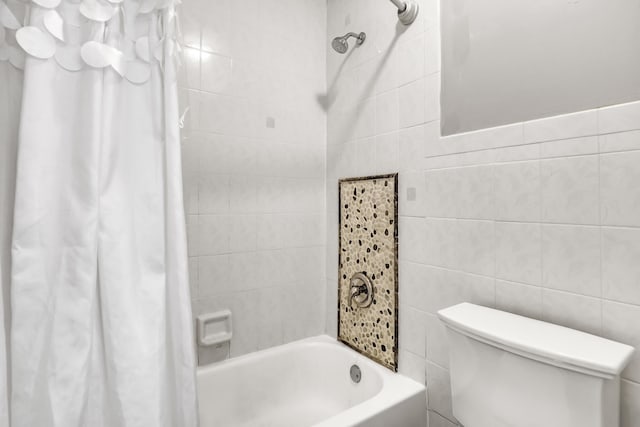 bathroom with toilet, tile walls, and shower / bath combo