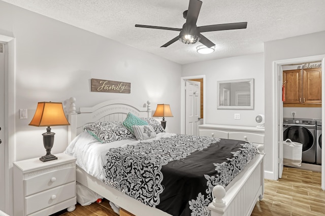 bedroom featuring ceiling fan, a textured ceiling, light hardwood / wood-style flooring, and washing machine and clothes dryer