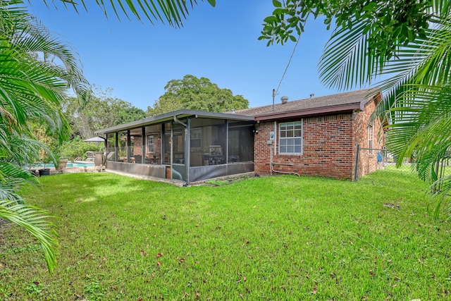 back of property featuring a sunroom and a lawn