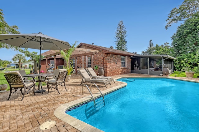 view of swimming pool with a patio area and a sunroom