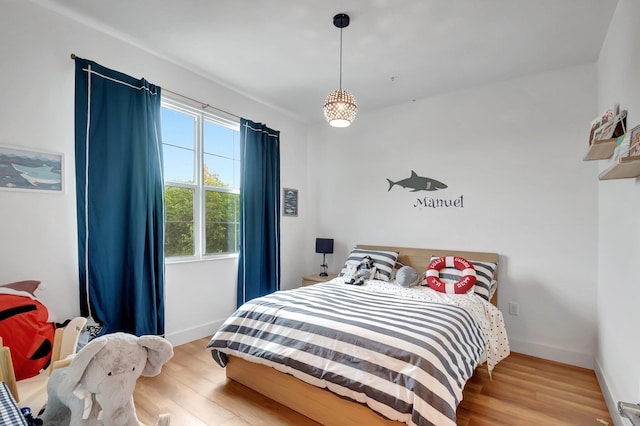 bedroom with light wood-style flooring and baseboards