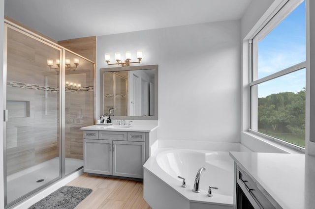 full bathroom featuring a chandelier, vanity, a shower stall, and a bath