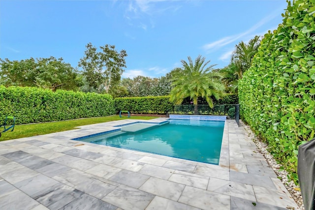 view of swimming pool featuring fence and a patio