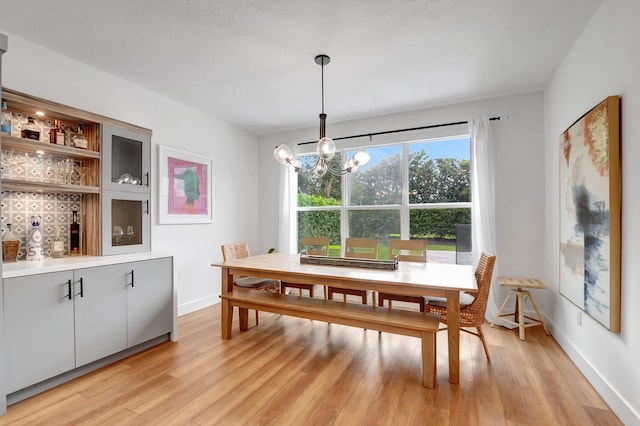 dining area featuring light hardwood / wood-style floors and an inviting chandelier