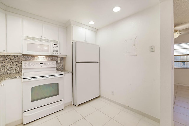 kitchen with backsplash, light tile patterned floors, white appliances, white cabinets, and light stone counters