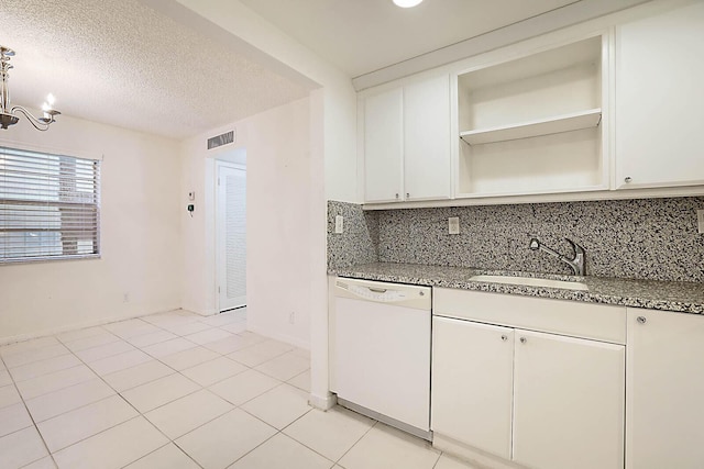 kitchen with dark stone countertops, decorative backsplash, sink, light tile patterned flooring, and white dishwasher