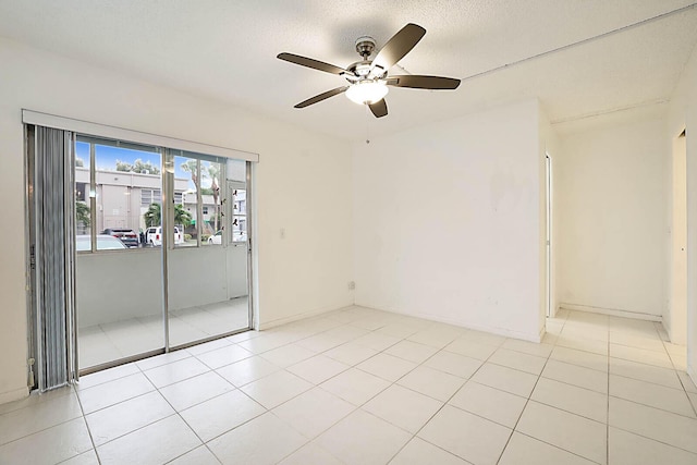 tiled spare room featuring a textured ceiling and ceiling fan