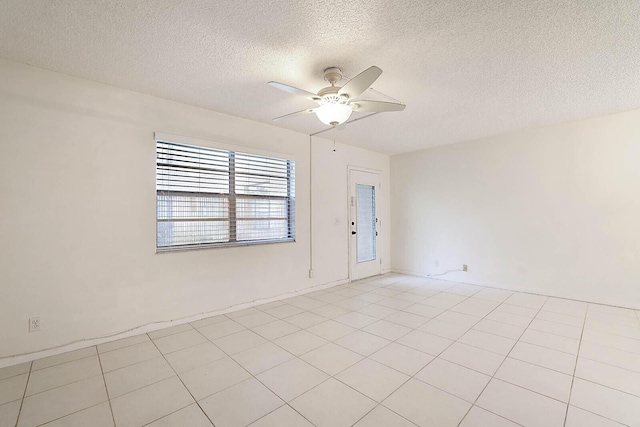 spare room with ceiling fan, a textured ceiling, and light tile patterned flooring