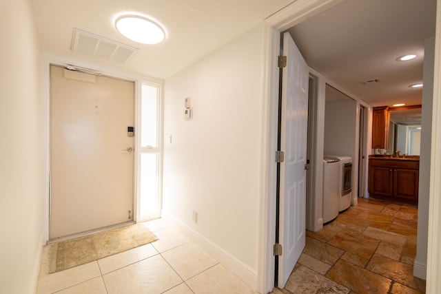 foyer entrance with recessed lighting, visible vents, washer and dryer, and baseboards