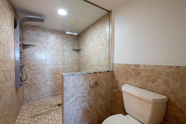 full bath featuring tile walls, toilet, wainscoting, and walk in shower