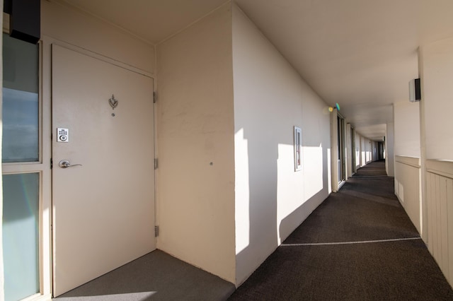 hallway with dark colored carpet