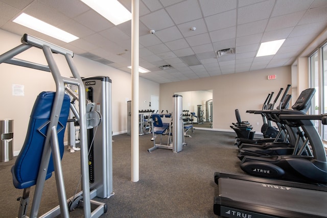 workout area featuring visible vents, a paneled ceiling, and baseboards