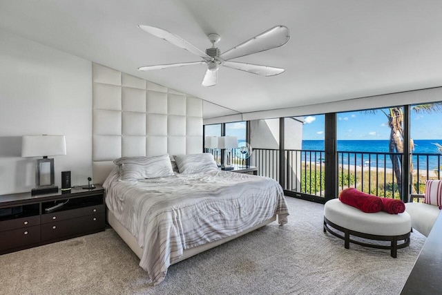 carpeted bedroom with a water view, access to outside, and ceiling fan