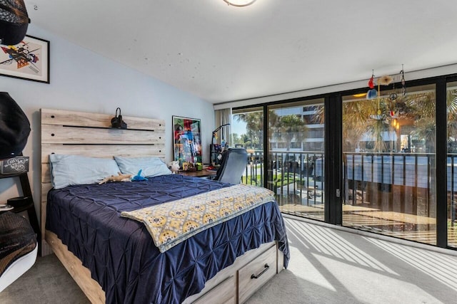 bedroom with carpet floors, expansive windows, and access to outside