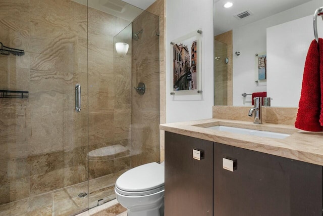 bathroom featuring vanity, toilet, and a shower with door