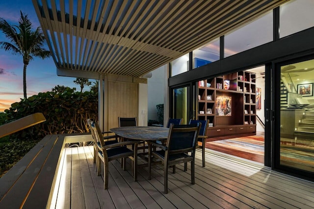 deck at dusk featuring a pergola