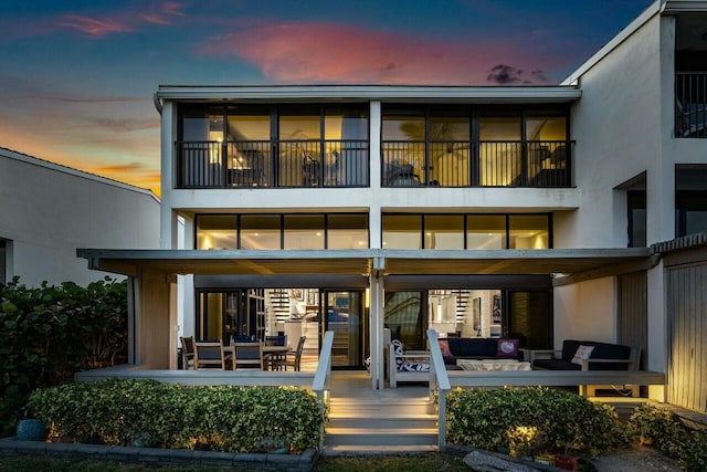 back house at dusk with outdoor lounge area