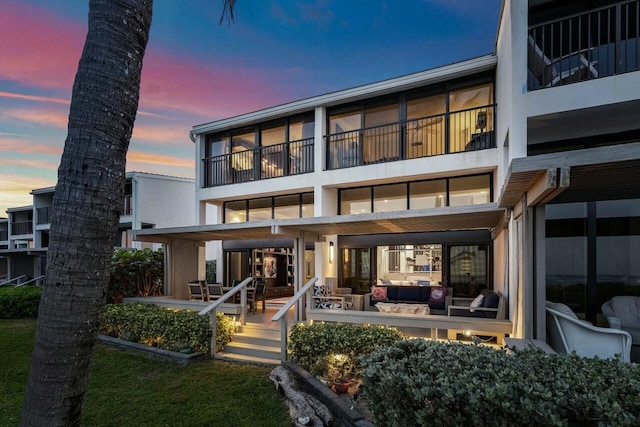 back house at dusk with an outdoor hangout area