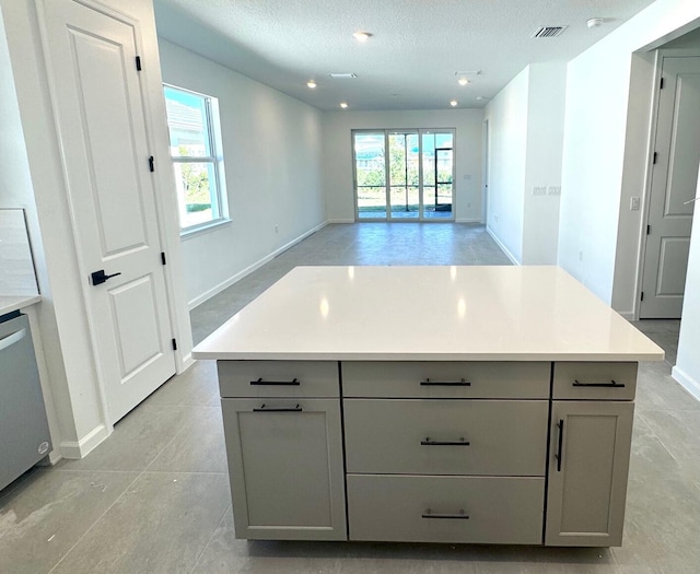 kitchen with a textured ceiling, visible vents, light countertops, gray cabinets, and dishwasher