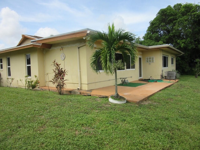 back of house featuring a patio area, a yard, and central AC unit