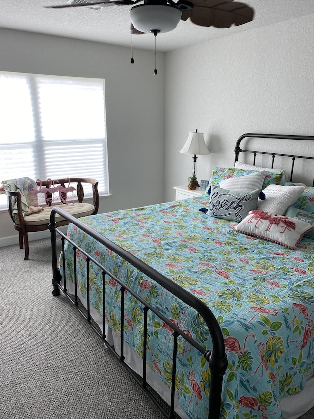 carpeted bedroom with ceiling fan and multiple windows